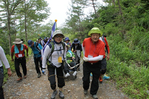 자원봉사자들이 중증장애인의 휠체어를 끌며 울산시 울주군 신불산 간월재를 오르고 있다. 경북지체장애인협회 김천시지회 제공