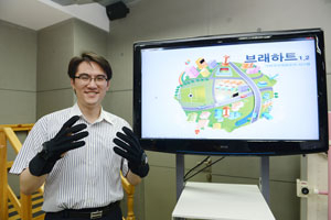 김영근 교수가 자신이 개발한 모션인식장갑을 착용하고 가상현실 재활시스템을 설명하고 있다.