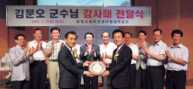 ▲대구 화원교회 비전센터 평생학습관 운영위원장 신용기(왼쪽) 목사가 김문오 달성군수에게 감사패를 전달하고 있다. 원교회 제공