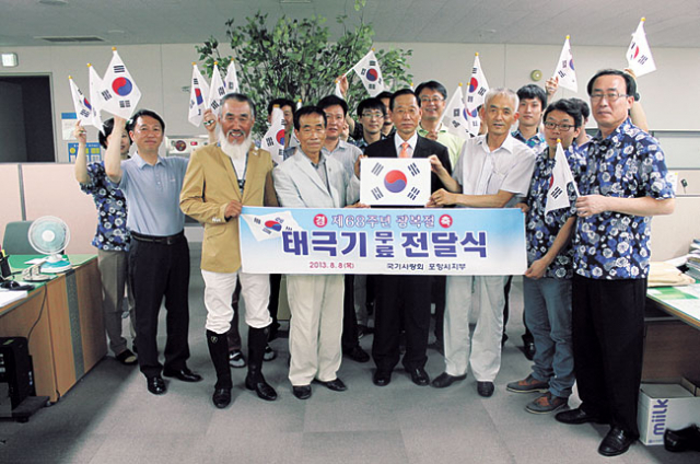 이상원(앞줄 왼쪽에서 두 번째) 국기사랑회장이 회원들과 함께 포항시를 찾아 태극기를 기증했다. 포항시 제공