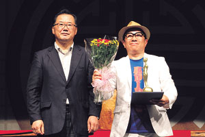 25회 거창국제연극제 폐막식에서 국내경연 대상을 차지한 극단 떼아뜨르 고도의 권영국(오른쪽) 대표가 신성범 새누리당 국회의원으로부터 트로피와 상장을 전달받고 기뻐하고 있다.