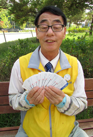35년간 265회 헌혈한 박규태 씨가 헌혈증서를 보여주며 환하게 웃고 있다.