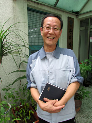 심폐소생술로 동료를 구한 경비원 최재영 씨가 아파트 관리사무소 앞에서 환하게 웃고 있다.