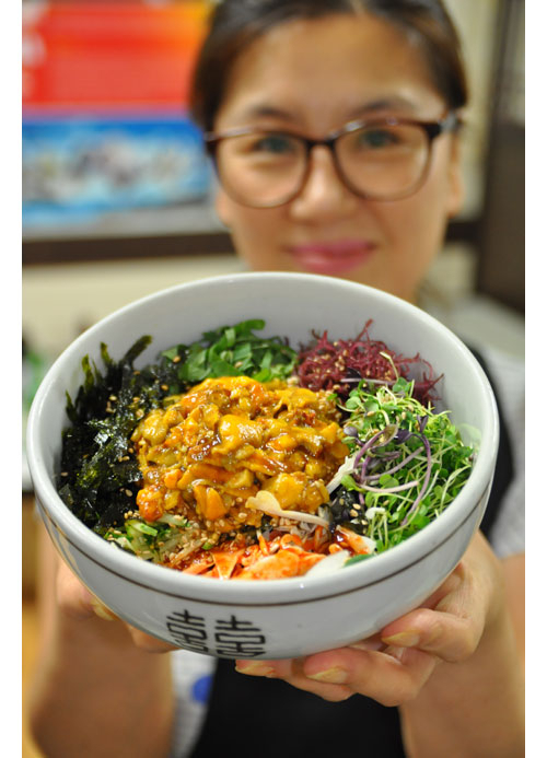 통영식도락 멍게비빔밥 전문점 정은숙(43) 씨가 갓 지은 밥 위에 새싹나물과 해조류와 함께 다진 멍게를 얹은 멍게비빔밥(덮밥)을 보여주고 있다.