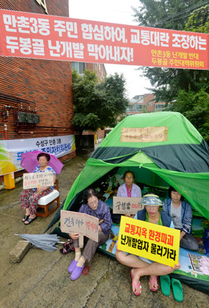 22일 대구 수성구 만촌동 두봉마을 주민들이 건축허가가 떨어진 부지 앞에서 텐트를 치고 난개발 반대 시위를 벌이고 있다. 두봉마을은 올 상반기에도 좁은 마을 안에 연립주택 등 4곳의 공사가 동시에 진행돼 먼지와 소음 등으로 주민 피해가 발생한 곳이다. 성일권기자 sungig@msnet.co.kr