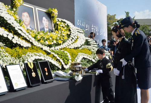 대구 대명동 가스 폭발사고 현장에서 순직한 고 남호선 경감와 전현호 경위의 합동 영결식이 26일 대구 남부경찰서에서 거행된 가운데 전현호 경위의 부인 지홍미 씨와 아들 재환 군이 헌화하고 있다. 성일권기자 sungig@msnet.co.kr