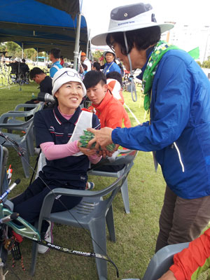전국장애인체육대회에서 동구여성봉사단원이 양궁선수에게 스카프를 선물하고 있다.