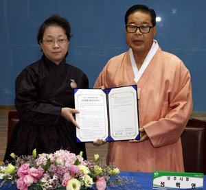 상주 명주로 만든 한복을 차려입은 성백영 상주시장이 26일 박현주 한복진흥원설립추진위원장과 상주에 한복진흥원건립을 공동추진하기 위한 협약을 체결했다. 상주시 제공