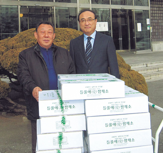 이영환(왼쪽) 경산 들풀애농원 대표가 새해 경북도청 공무원들에게 친환경 쌈채소 꾸러미를 공급하기에 앞서 김준식 경상북도 친환경농업과장과 기념촬영을 하고 있다. 경북도 제공