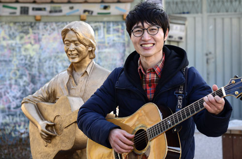 지난 22일, 대구 김광석 거리에서 활짝 웃고 있는 김광석 동상 앞에 가수 채환이 기타를 들고 섰다. 이날 
