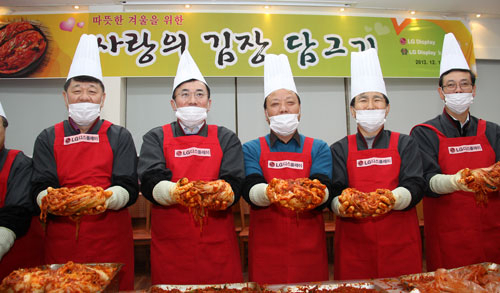 LG디스플레이 정철동 부사장(왼쪽 두 번째)과 석호진 노조위원장(왼쪽 세 번째) 등 임직원들이 작년 12월 구미지역의 소외계층, 사회복지시설 등에 전달할 김장을 담그는 모습. LG디스플레이 제공