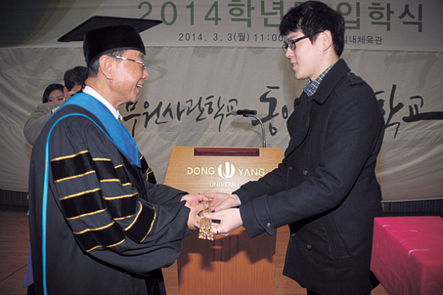 3일 열린 동양대 입학식 집지 행사에서 표우석 학생대표가 최성해 총장에게 예폐(禮幣)로 회초리를 올리고 있다.