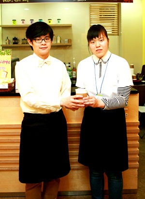 카페 위(경산캠퍼스 대구대점)에서 바리스타로 일하고 있는 박영석(왼쪽) 씨와 실습생 정영현 씨가 직접 만든 커피를 들고 기념사진을 찍고 있다. 대구대 제공