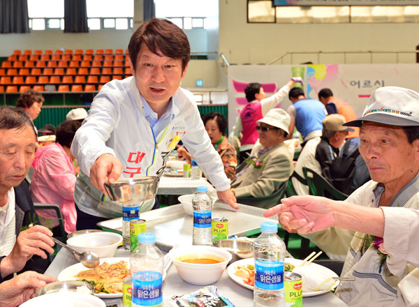 권영진 새누리당 대구시장 후보(사진 위)가 김부겸 새정치민주연합 대구시장 후보와 19일 대구시민체육관에서 열린 시각장애인 경로잔치에서 급식 자원봉사를 하며 어르신들에게 지지를 호소하고 있다. 정운철 기자 woon@msnet.co.kr