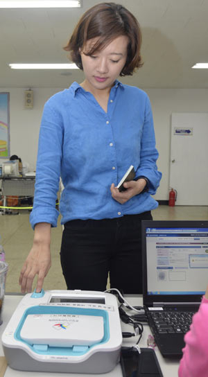 대구 남구에 거주하는 본사 김봄이 기자가 30일 달서구 도원동 주민센터에 마련된 사전투표소에서 투표 전 지문인식기를 이용해 본인 확인을 하고 있다. 성일권 기자 sungig@msnet.co