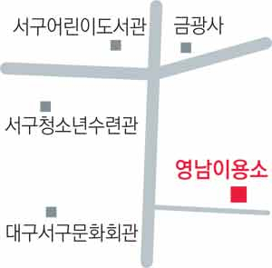 금봉해 사장이 필름 카메라를 손에 들고 사진관의 역사를 설명하고 있다. 오른쪽 선반에 있는 필름 카메라들은 모두 금 사장이 수집한 것이다.