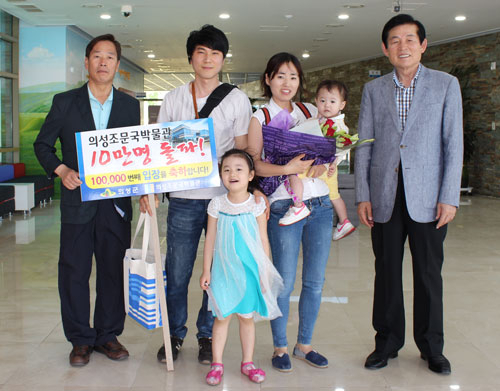 의성 조문국박물관은 지난달 25일 10만 번째 입장한 최명수 씨 가족에게 전통시장 상품권과 기념품을 전달했다. 김복규 의성군수(오른쪽) 최명수 씨 가족(가운데), 김영한 조문국박물관장(왼쪽). 의성군 제공