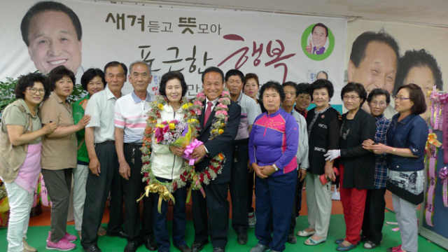 만 군위군수 당선인이 지지자들과 함께 환하게 웃고 있다.