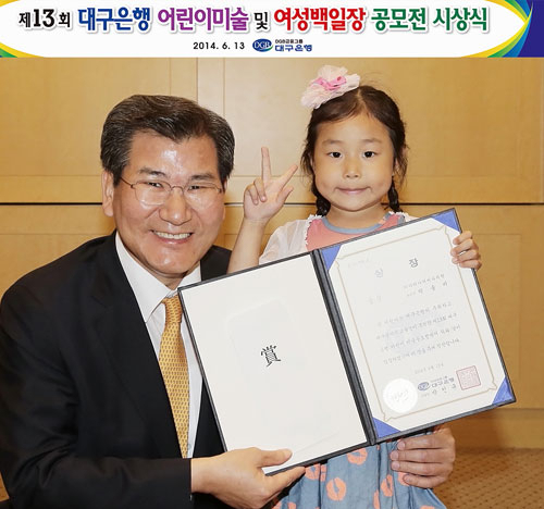 박인규 대구은행장(왼쪽)과 대구은행 2014 어린이미술 공모전 유치원부 금상 수상자 박솔비 양.