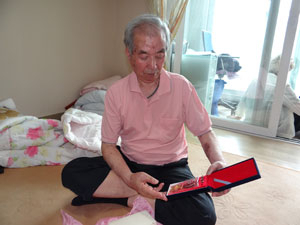 권태환 할아버지가 전쟁 때 받은 훈장을 꺼내 바라보고 있다. 훈장뿐만 아니라 케이스 조차 세월의 때가 잔뜩 묻어 있는 모습이다. 이화섭기자.