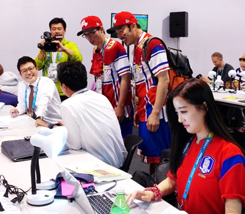 포르투 일레그리의 베이라히우 경기장 앞에서 붉은색 티셔츠를 입은 한국 응원단과 브라질 시민이 함께 