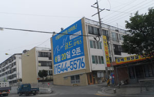 수백m 밖에서도 보이는 아파트 벽면 전체를 이용한 불법 현수막, 단속권한을 가진 관계기관이 쉽게 철거할 수 없다는 점을 노려 아파트 건설업체들이 불법 현수막을 마구잡이로 내걸고 있다, 신현일 기자