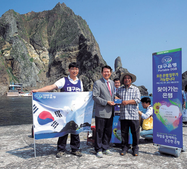▲독도주민 김성도 씨가 대구은행 포터블DGB를 통해 대구은행 독도예금에 가입했다. 대구은행 제공