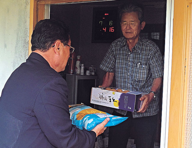 ▲이병인(왼쪽) 영천시 서부동장이 홀몸노인에게 감자를 전달하고 있다. 영천시 제공