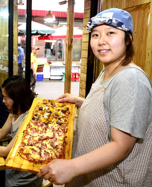 서문시장 1지구 상가에서 가창송하피자 가게를 운영하는 장지예 씨가 갓 구운 피자를 들어 보이고 있다. 이채근 기자 mincho@msnet.co.kr
