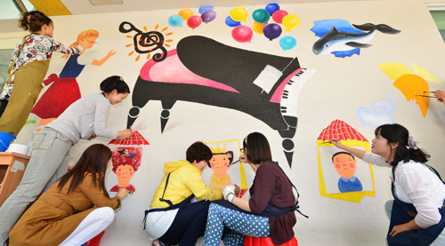 21일 오전 대구죽곡초등학교 학부모들이 학교 건물 내 담벼락에 바닷속 풍경 등 동화를 주제로 한 