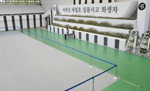 세월호 참사 100일을 이틀 앞둔 22일 세월호 침몰사고 희생자 합동분향소가 마련된 대구 두류공원 안병근올림픽기념유도관에 한 조문객이 찾아와 조문하고 있다. 합동분향소에서 조문객을 안내하는 공무원은 