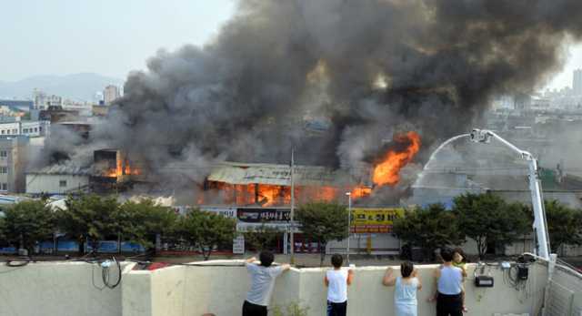 27일 대구 서구 원대가구골목 일대에서 대형화재가 발생하자 놀란 인근 주민들이 주택 옥상에서 안타까운 심정으로 소방대원들의 화재 진압을 지켜보고 있다. 성일권 기자 sungig@msnet.co.kr