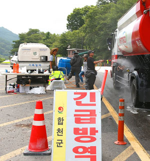 고령군에서 합천군으로 진입한 축산사료 차량을 야로면 분기 구제역 통제초소의 방역팀이 방역을 하고 있다.