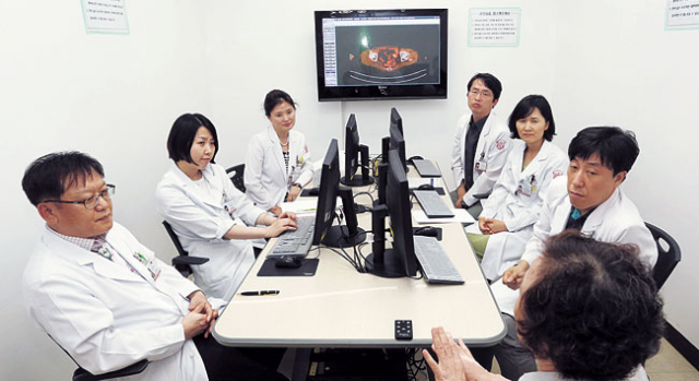 ▲계명대 동산병원 산부인과, 혈액종양내과, 영상의학과, 방사선종양학과, 핵의학과 전문의들이 암센터 진료실에 모여 난소암 환자 최모 씨와 검사결과, 치료방법 등에 대해 이야기를 나누고 있다.