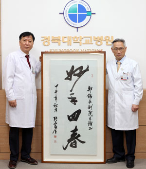 경북대병원 정호영(왼쪽) 외과교수와 조병채 경북대병원장이 중국 중기투자그룹 부회장이 아내의 암 수술을 성공적으로 시술해 준 보답으로 보낸 서예작품 