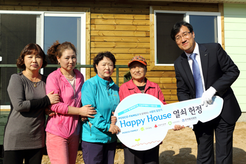 박현(오른쪽) 포스코 사회공헌그룹 상무가 박유순 할머니와 가족들에게 해피하우스 열쇠를 전달하고 있다. 이영욱 기자