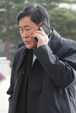 최경환 경제부총리가 4일 전화통화를 하며 국회 본청에 들어서고 있다. 연합뉴스