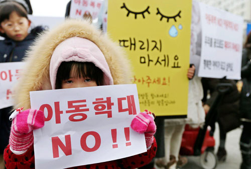 인천 어린이집 아동학대 사건의 파문이 커지는 가운데 18일 오후 인천시 연수구 송도 센트럴공원에서 한 여아가 어린이집 아동학대 근절을 촉구하는 피켓을 들고 있다. 2015.1.18/연합뉴스