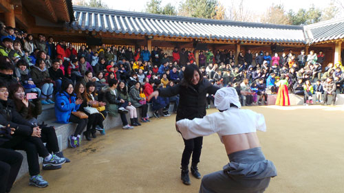 하회별신굿탈놀이 할미미당에서 할미탈이 관객을 불러내 함께 덩실덩실 어깨춤을 추고 있다.