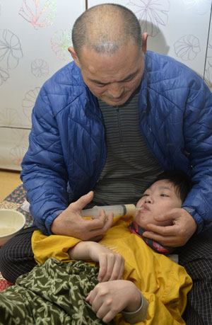 윤영수 씨는 퉁퉁 부은 다리 위에 딸 슬기 씨를 눕혀서 밥을 먹인다. 슬기 씨는 내년이면 서른이지만 아직 기저귀를 차고 제대로 걷지도 못해 갓난아기나 다름없기 때문이다. 어릴 적 큰 교통사고를 겪은 이후 슬기 씨는 뇌병변 1급 장애를 갖게 됐다. 성일권 기자 sungig@msnet.co.kr