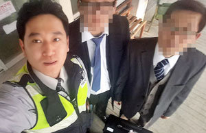 설 명절을 맞아 고국을 처음 방문한 재일교포 이성로 씨와 아들이 6천여만원 상당의 금품이 든 돈가방을 찾아준 상주경찰서 조유호 경사와 함께 기념촬영을 하고 있다. 상주경찰서 제공
