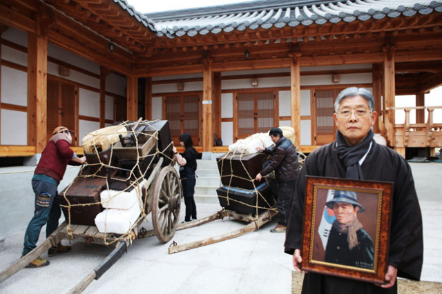 광복 70주년 기념행사로 28일 도만(渡滿) 구국 행렬을 준비하고 있는 항일순국지사 추산 권기일 선생의 손자 권대용(67) 종손이 25일 오후 예미정 별관 마당에서 짐을 꾸리다가 할아버지 초상화를 들고 잠시 포즈를 취하고 있다. 권동순 기자