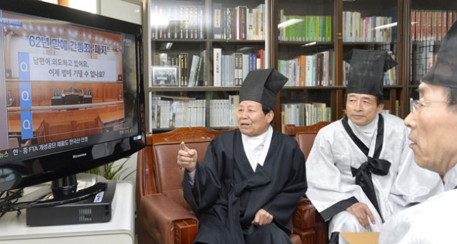 헌법재판소가 간통죄 처벌조항에 대해 위헌 결정을 내린 26일 대구향교에서 김필규(왼쪽) 전교와 유림들이 TV로 헌재 결정을 시청하면서 대화를 나누고 있다. 성일권 기자 sungig@msnet.co.kr