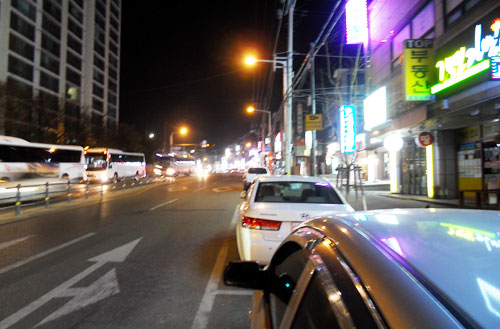지난 9일 오후 10시 30분쯤 석적읍 중리 부영아파트와 LG디스플레이 나래원 기숙사 앞 도로. 식당과 유흥업소가 불야성을 이루고 있는 가운데 LG디스플레이 교대근무자를 위한 통근버스(왼쪽)가 줄지어 이동하고 있다. 이영욱 기자