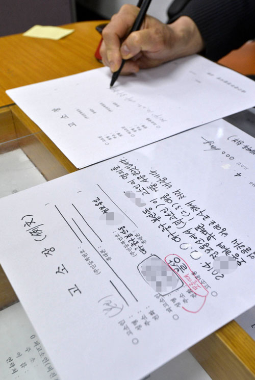 대구 중구 소재 한 휴대폰 대리점에서 명의를 도용당했다는 피해자들이 속출하고 있다. 16일 중부경찰서 민원실에서 해당 사건 피해자가 고소장을 작성하고 있다. 우태욱 기자 woo@msnet.co.kr