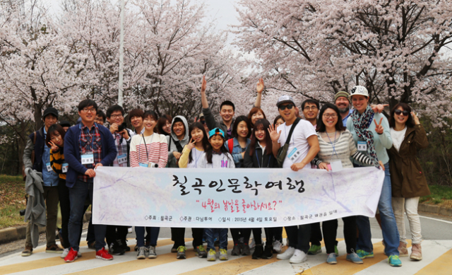 ▲이달 4일 칠곡군 왜관읍 매원2리 감호당 고택에서 열린 칠곡군 인문학 공정여행 참가자들이 마을 진입로에 만개한 벚꽃을 만끽하고 있다. 칠곡군 제공