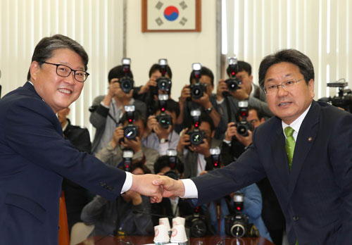 국회 공무원연금특위 여야 간사인 새누리당 조원진(왼쪽), 새정치민주연합 강기정 의원이 20일 오전 국회 안행위 소회의실에서 만나 악수하고 있다. 연합뉴스