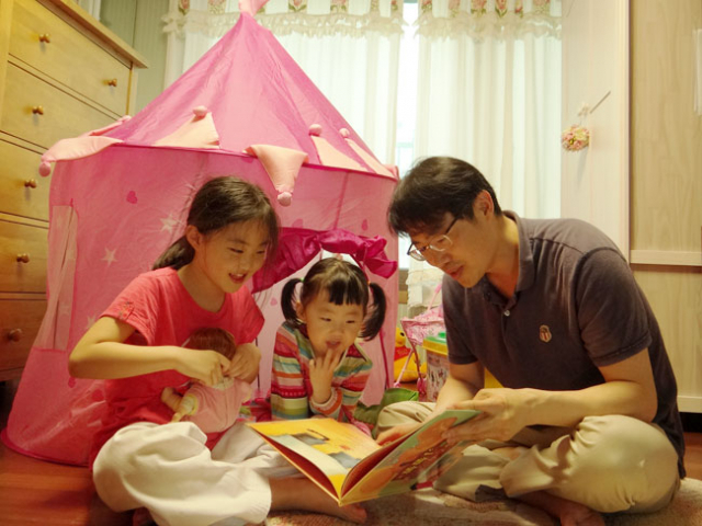 도경용(39) 씨가 학교와 학원 공부를 끝마치고 돌아온 큰딸 민주(9) 양과 어린이집에서 돌아온 작은딸 유빈(4) 양에게 책을 읽어주고 있다. 민주와 유빈이는 아버지 곁에서 잠시도 떨어져 있지 않으려 할 정도로 아버지와 함께 있는 것을 좋아했다. 이화섭 기자