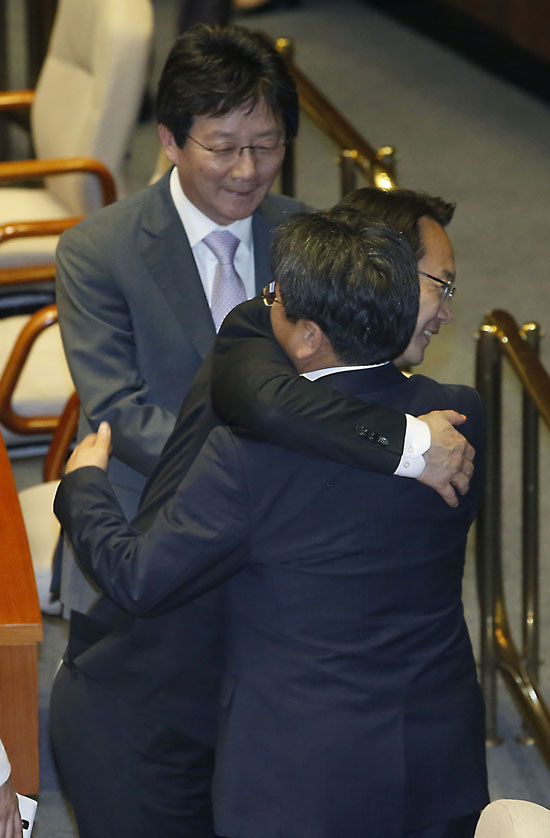 새누리당 조해진 원내수석부대표(가운데)와 새정치민주연합 강기정 정책위의장이 29일 국회에서 제333회 국회(임시회) 제3차 본회의를 마친 뒤 포옹을 하고 있다. 연합뉴스