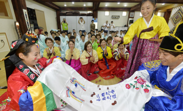 대구시 초청으로 15일 대구를 찾은 중국, 대만 등 중화권 관광가이드 70여 명이 한국전통문화체험관에서 한복을 곱게 차려 입은 뒤 전통혼례 체험을 하고 있다. 성일권 기자 sungig@msnet.co.kr